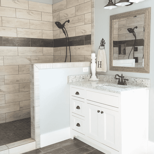 A bathroom with a white vanity, floor to ceiling tile shower and walls painted in silvermist sw 7621 by @lovehurtts.