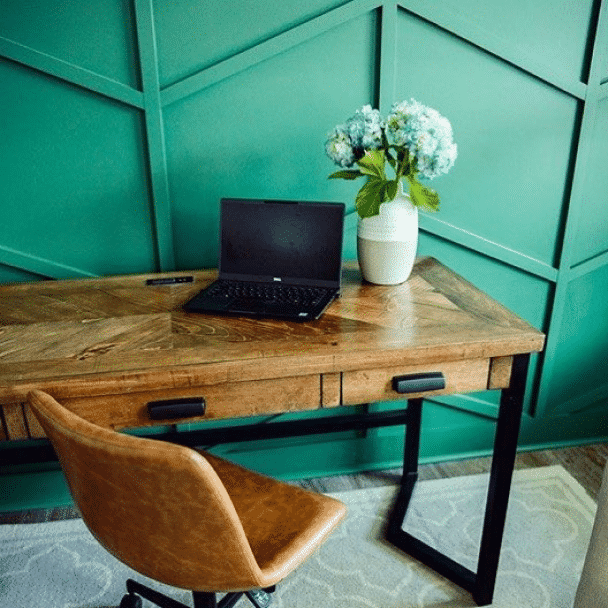 A home office with a wooden desk in front of a wall painted in kale green sw 6460 by @carolinareclaimed.
