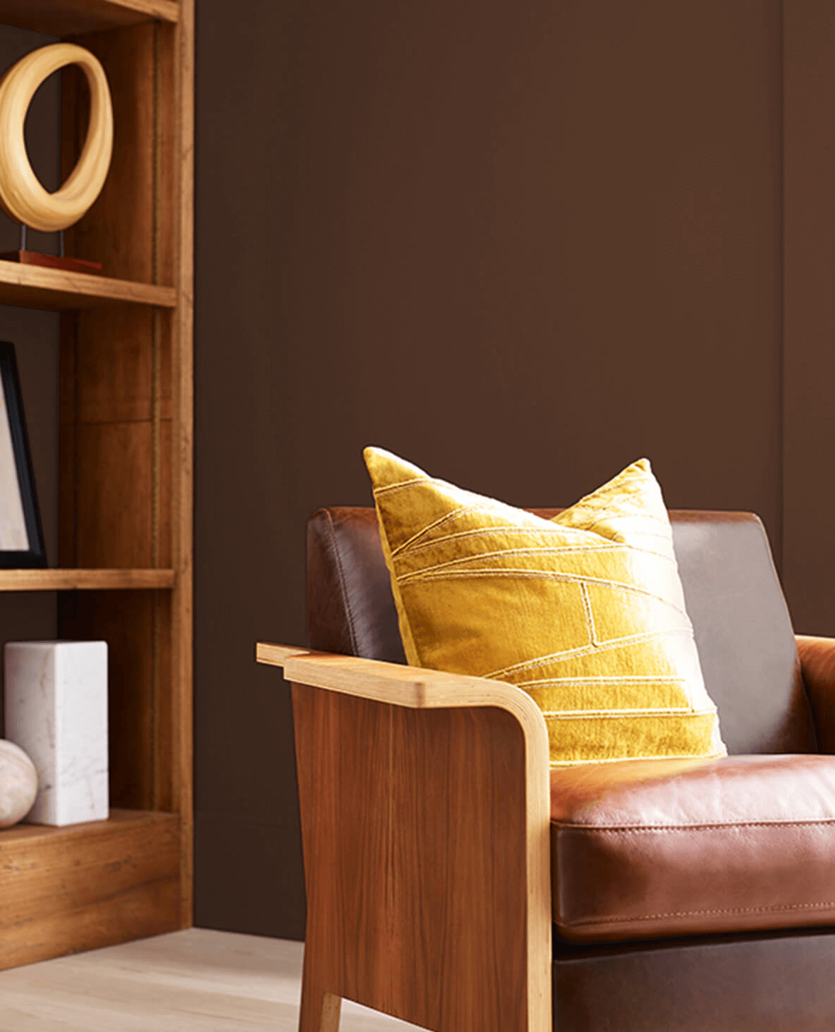 brown leather chair against a rich brown wall.