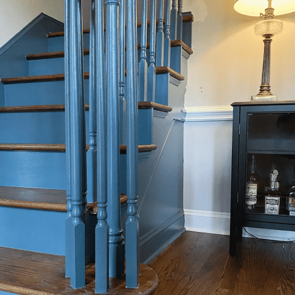 Blue stairs next to a wall with the wainscoting painted in needlepoint navy sw 0032 by @lesliehere_.