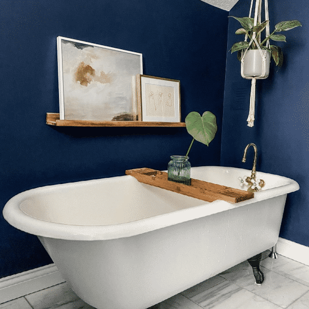 A bathroom with a large tub and walls painted in naval sw 6244 by @ourbrickcottage.