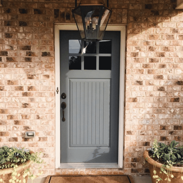 An exterior door to a home painted in roycroft pewter sw 2848 by @theboxwood_diaries.