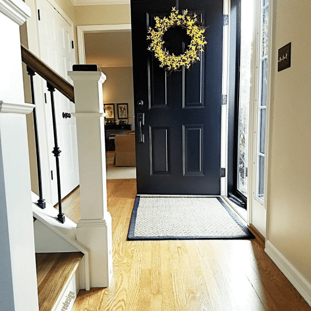 A foyer with a blue door and walls painted in kilim beige sw 6106 by @finaltouchesredesign.