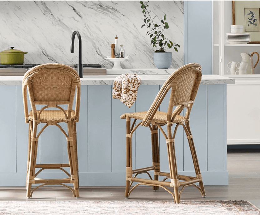 Two rattan chairs at a kitchen island painted 2024 Color of the Year, Upward SW 6239.