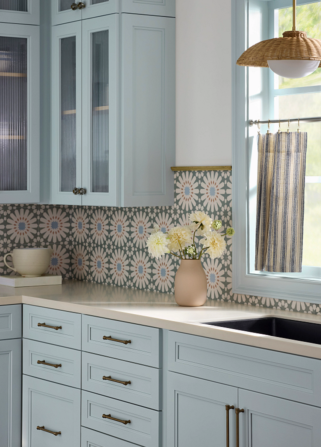 Kitchen cabinets painted in SW 6218 Tradewind, printed backsplash.
