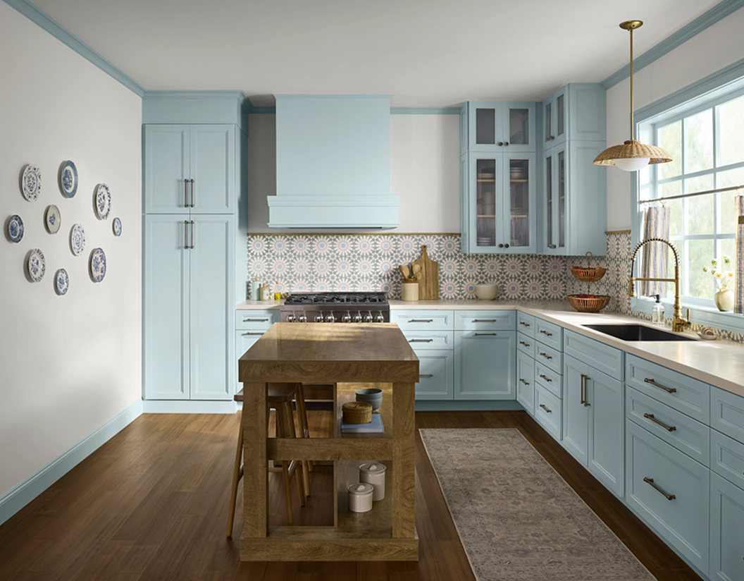 Kitchen cabinets painted in SW 6218 Tradewind, printed backsplash.