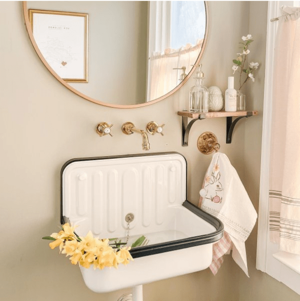 A retro bathroom painted a warm neutral with rose gold accents by @gatheredliving.