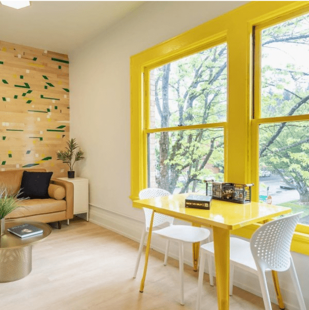 A sitting area with bright yellow trim around a window by @the505eugene.