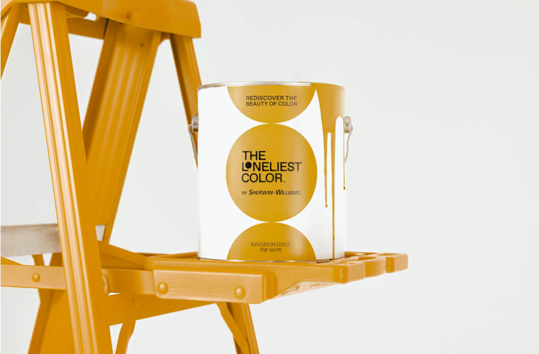 A can of Sherwin-Williams' Loneliest Color sitting a Kingdom Gold painted ladder.
