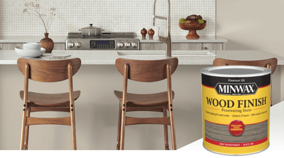 Three wooden chairs stained a medium brown sit pulled up to a kitchen island counter. Minwax wood finish penetrating stain.