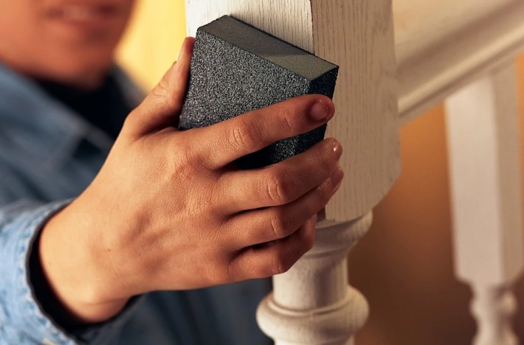 Person sanding a banister. 