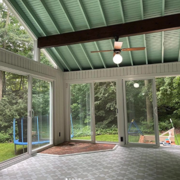 Sunroom with Windows looking into the yard with a trampoline, done by kindgreen macfarland painting.