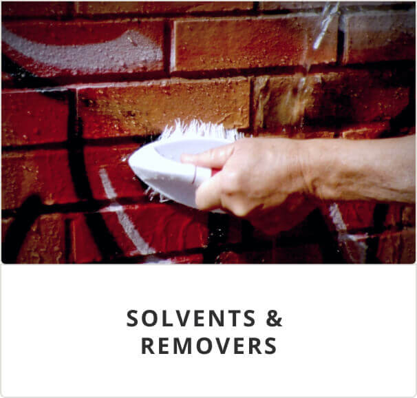 Solvents and removers. A person using a scrub brush on a brick wall.