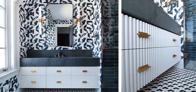 Full view and angled closeup of fluted white vanity with dark countertop and bold patterned wallpaper, dark blue tiled walk-in shower at right.