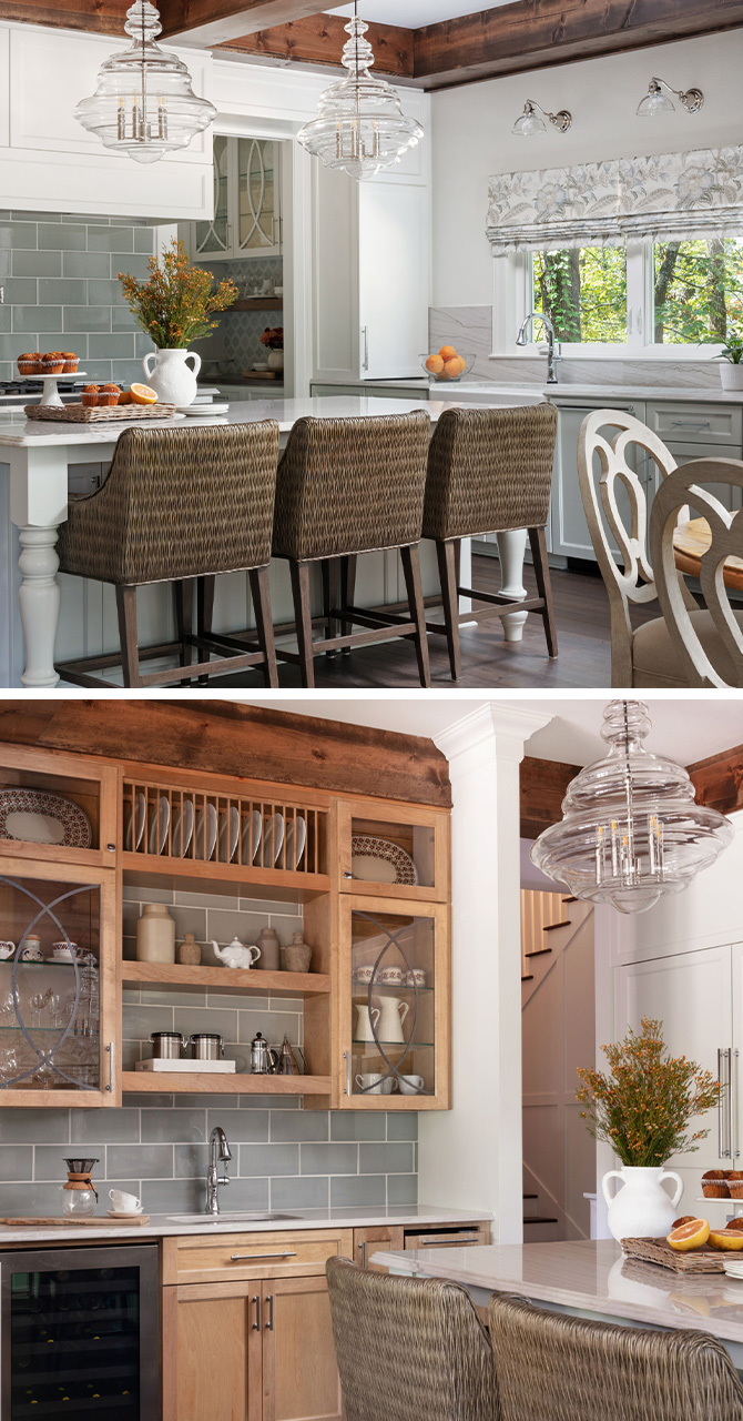 Kitchen with white walls, glass-front wood cabinets, and natural wood ceiling beams, woven chairs at dine-in island, and two statement glass chandeliers.