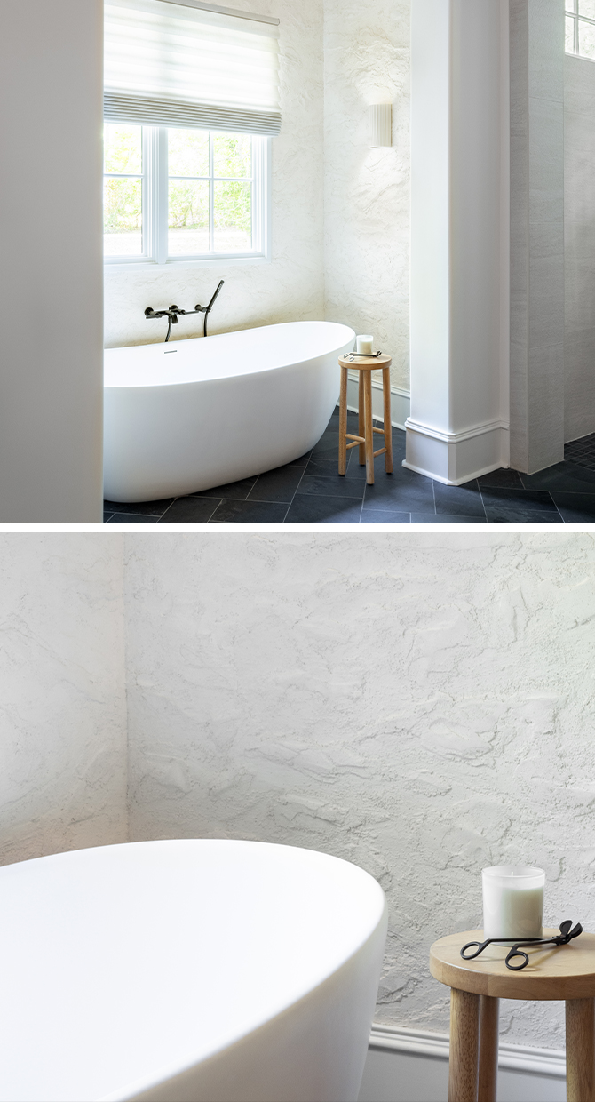 Modern bathroom with a freestanding bathtub, textured walls painted Sherwin-Williams Cotton, and stone tiles.