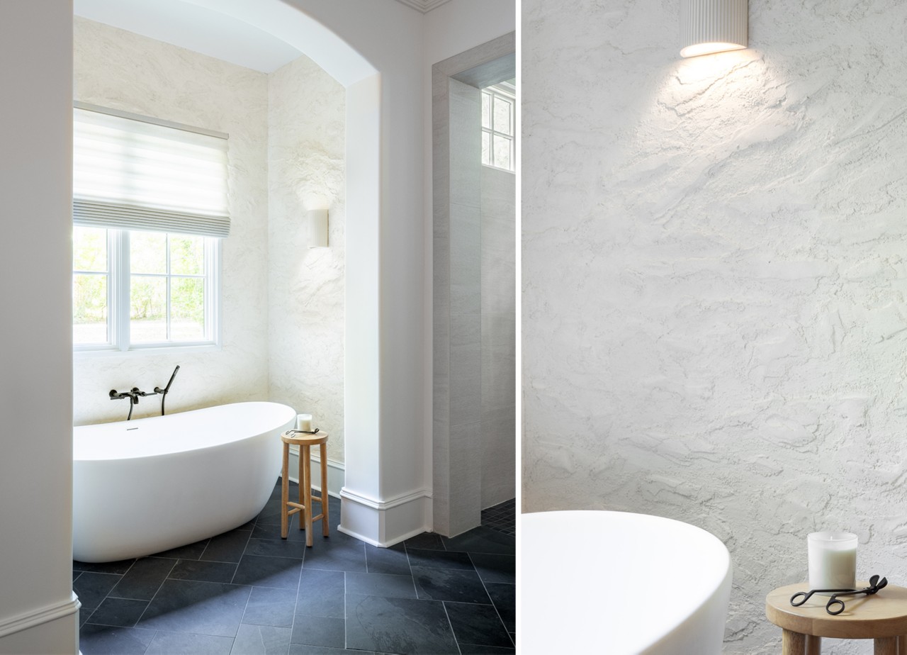Modern bathroom with a freestanding bathtub, textured walls painted Sherwin-Williams Cotton, and stone tiles.