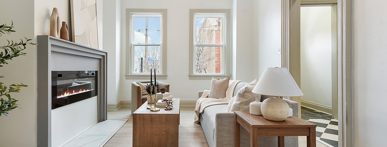 Modern living room with electric fireplace, neutral furniture, and large windows painted in Sherwin-Williams Pure White and Accessible Beige.