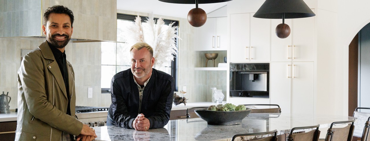 Designer Aly Velji and husband Jason Krell standing at the marble island in their newly renovated kitchen.