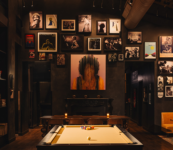 Stylish restaurant interior with a pool table, eclectic wall art, and cozy seating.