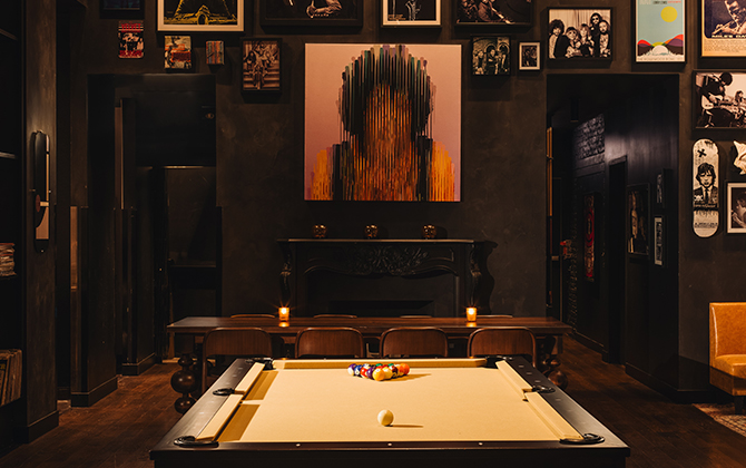 Stylish restaurant interior with a pool table, eclectic wall art, and cozy seating.