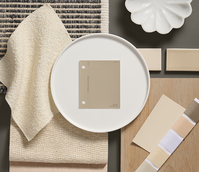 Flat lay of neutral-toned materials, featuring a Universal Khaki color swatch on a white plate, beige fabrics, tiles, and thread samples.