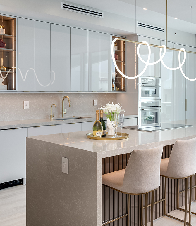 Modern kitchen with a light and airy color scheme, including white cabinets, stone countertops, and beige accents. 