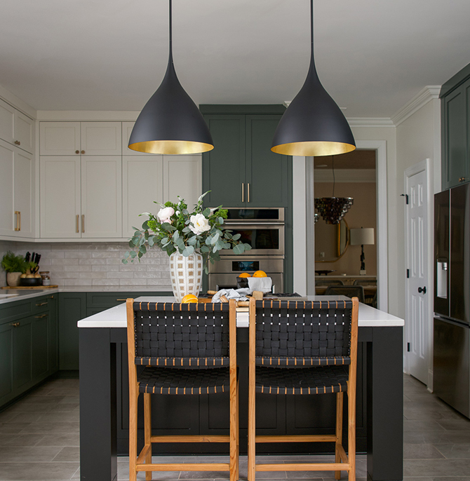 Modern kitchen with a central island painted Caviar by Sherwin-Williams, pendant lights, Pewter Green and Greek Villa cabinets, Drift of Mist walls, and a vase with flowers.