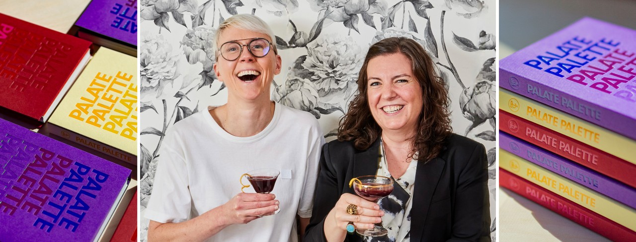Colorful books with "PALATE PALETTE" on covers, Lish Steiling and Abbey Cook smiling with drinks, and a stack of their Palate Palette cookbooks.