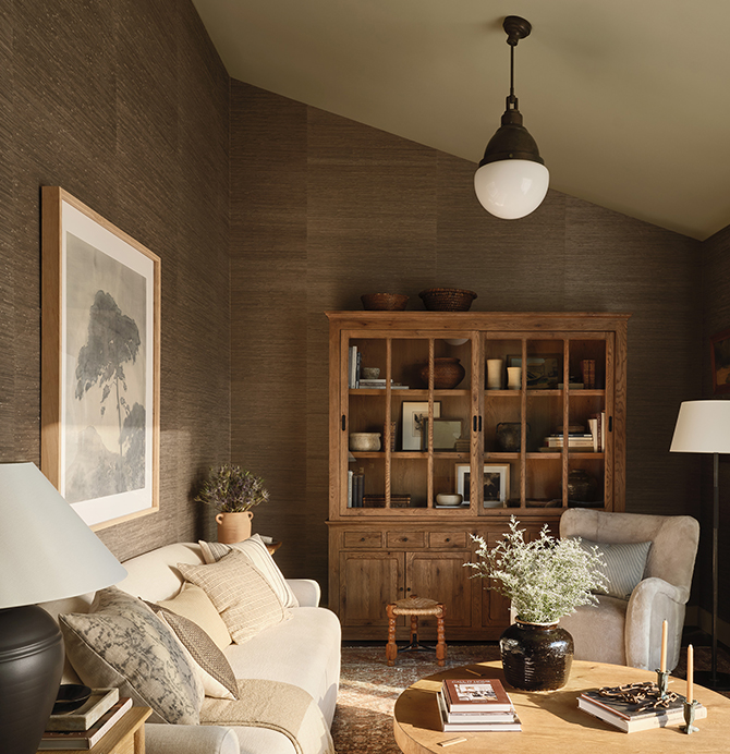 Cozy living room with beige sofa and wooden furniture, featuring earth-toned decor and soft lighting.