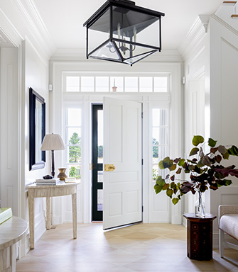 An entrance to a home with a white front door and walls painted with Cotton SW 9581.