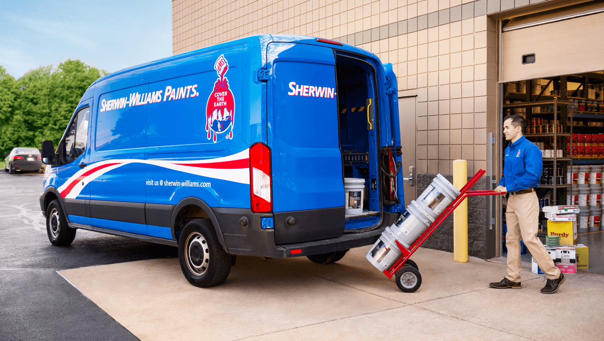 A Sherwin-Williams employee loading a delivery van with paint.