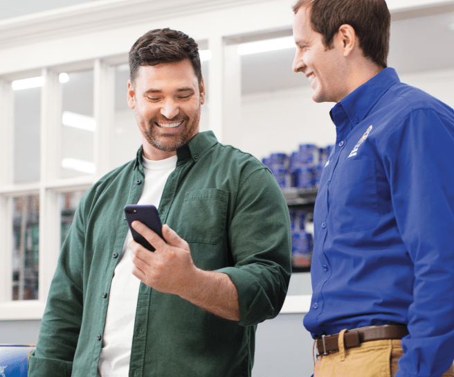 A painter and Sherwin-Williams employee looking at a phone.