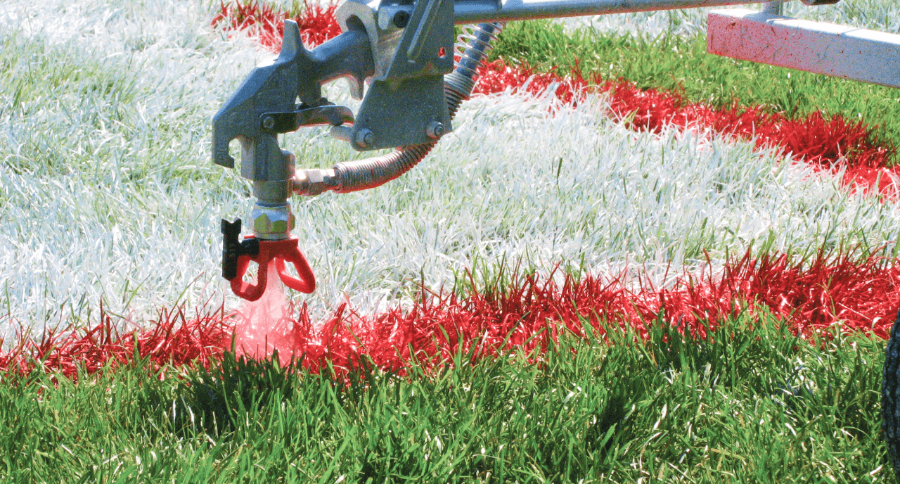 A field being sprayed with red paint.