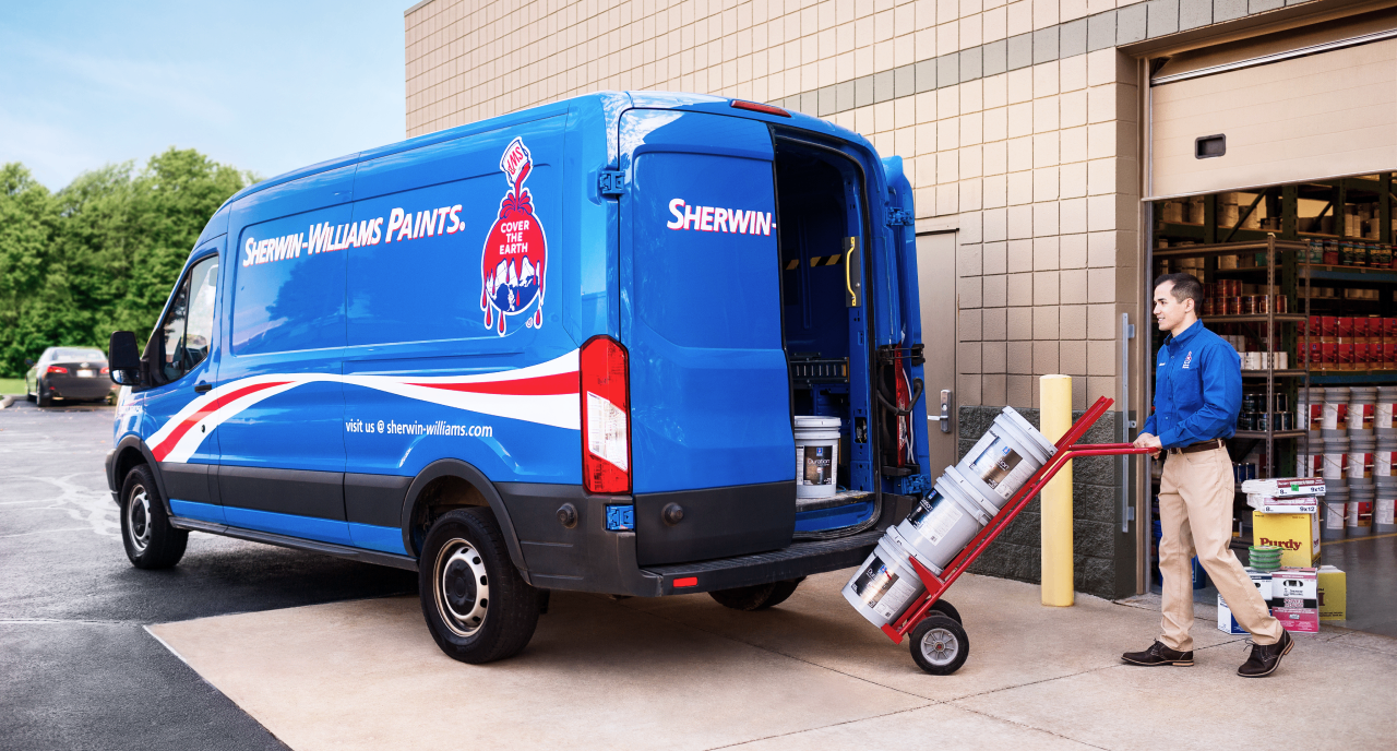 A Sherwin-Williams employee loading paint into a delivery van.