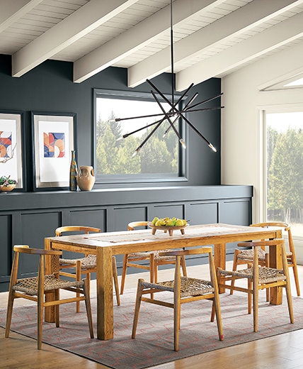 A cozy dining room with wood table, designer rug and gray wall. S-W colors featured: sw 7076 Cyberspace.