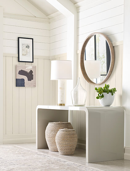 A white entryway with shiplap walls and vaulted ceiling.