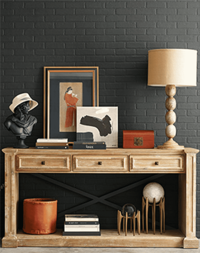 Dark gray brick wall with a wooden table filled with decor.