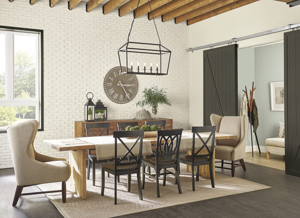 Dining room with SW 9611 Minimalist colored walls, SW 7048 Urbane Bronze interior barn door, and wooden table.  