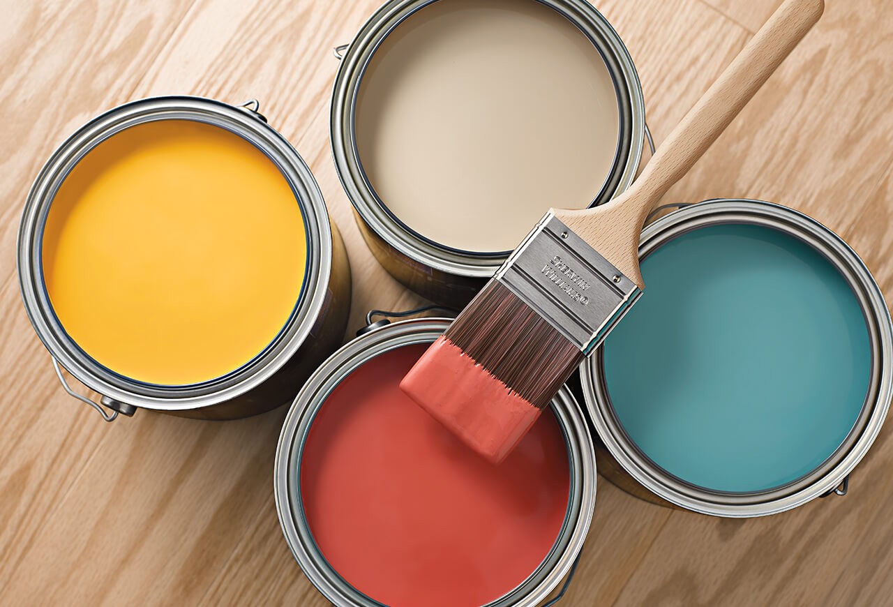 Four cans of yellow, beige, blue and red paint