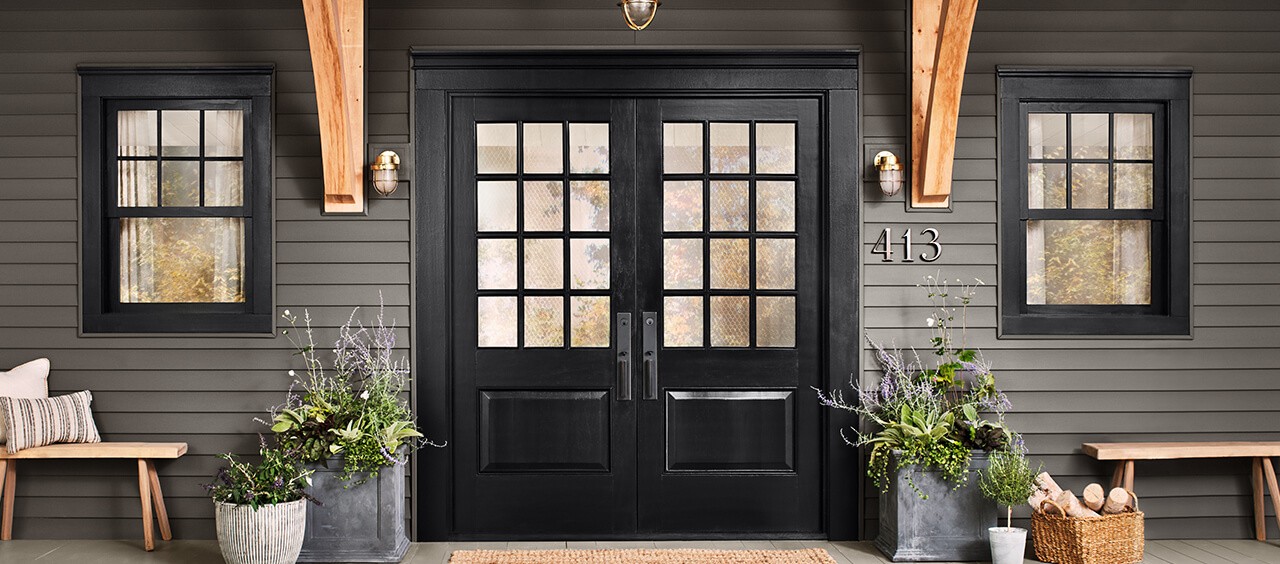 A set of black front doors with windows.