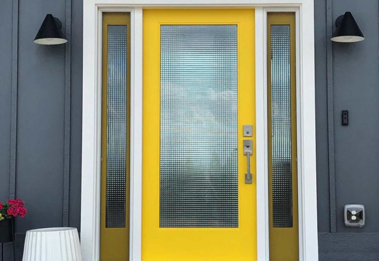 A yellow front door with glass windows.
