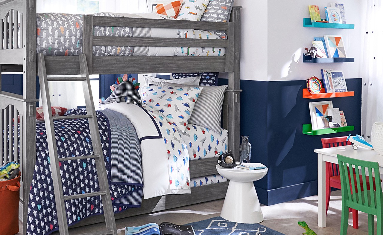 A dinosaur themed bedroom with bunk beds and navy blue walls.