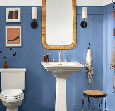 A blue bathroom with pedestal sink and vanity mirror