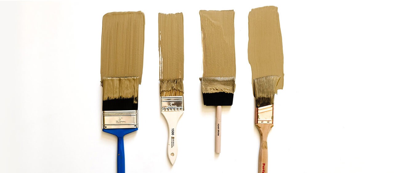 A set of four paint brushes with beige paint swatches.