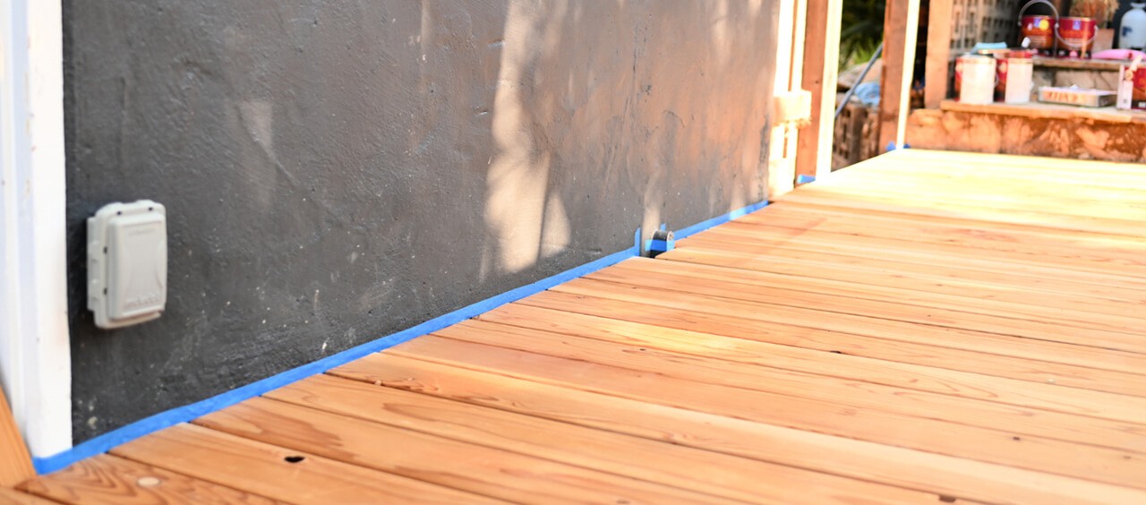 An unfinished outdoor deck with masked tape.